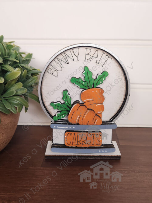 Mini Snow Globe, White Bunny Bait background, Orange Carrots Sign, two orange carrots with green tops.